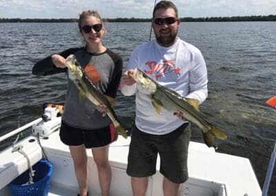 couple holding a fish caught on a Seein Red Sportfishing Charter