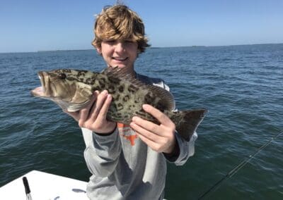 kid holding a fish caught on a Seein Red Sportfishing Charter