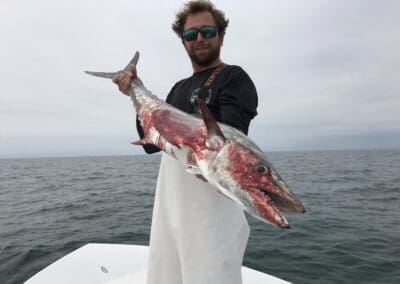 Captain Spencer holding a fish caught on a Seein Red Sportfishing Charter