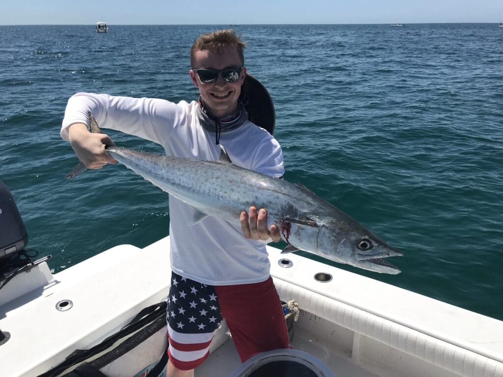 man holding a fish caught on a Seein Red Sportfishing Charter