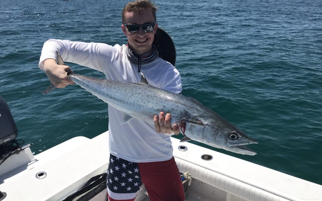 man holding a fish caught on a Seein Red Sportfishing Charter