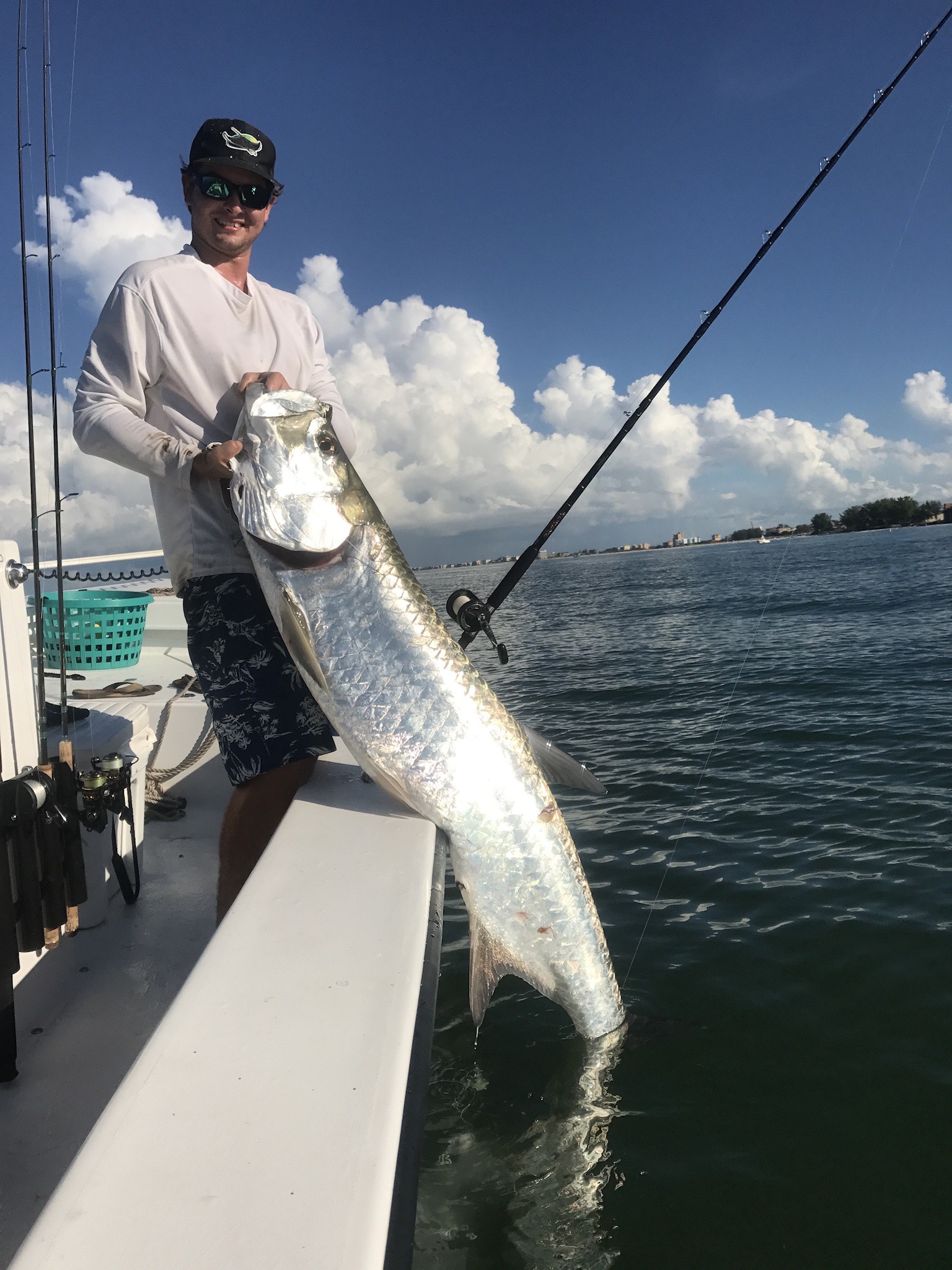 Man holding a tarpon he caught in Tampa Bay while inshore fishing