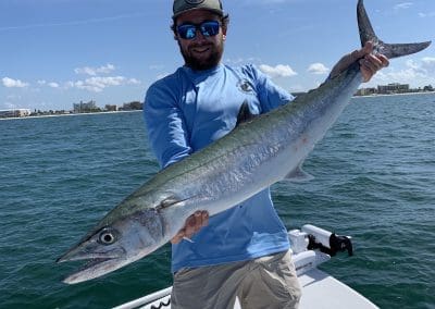 captain spencer the owner of seein red sport fishing charters holding a large fish