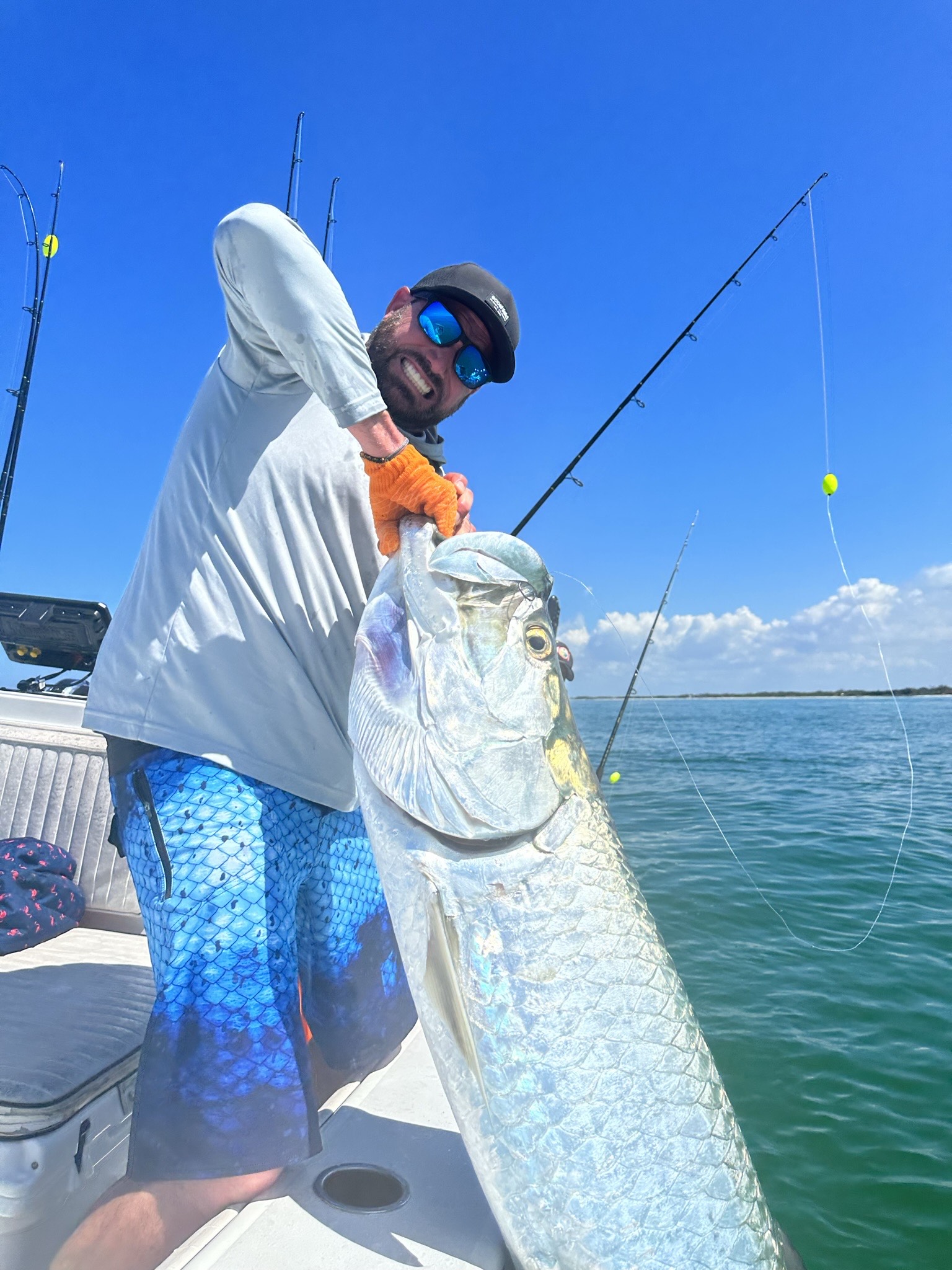 man t holding a tarpon he caught near John's Pass