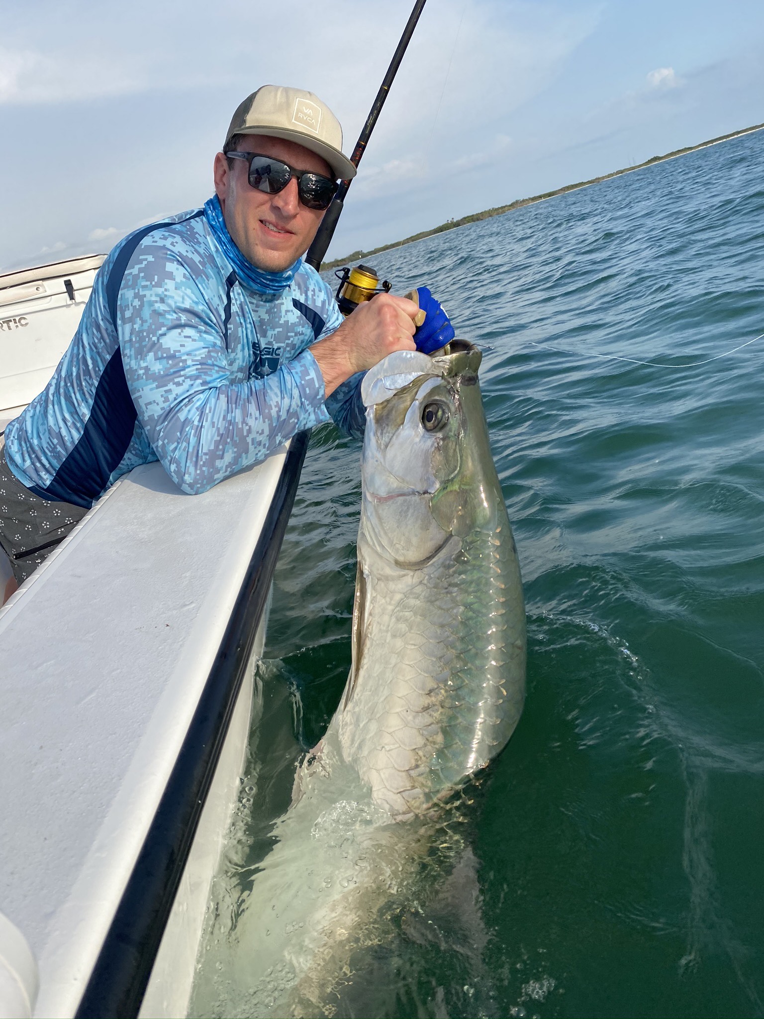 man holding a tarpon caught in the gulf waters